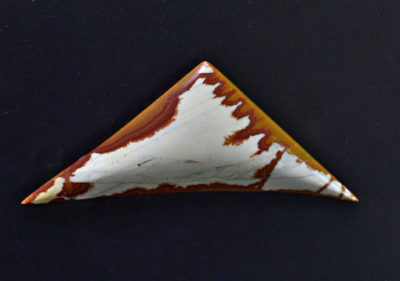 A triangular piece of agate on a black surface.