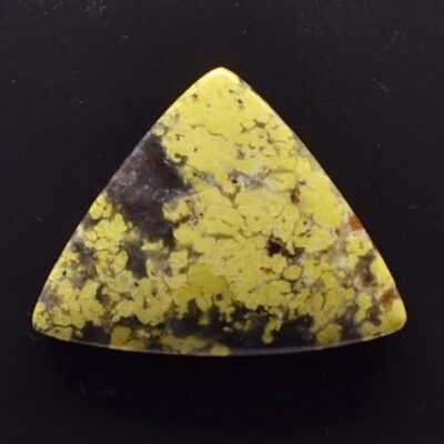 A yellow and black stone triangle on a black surface.