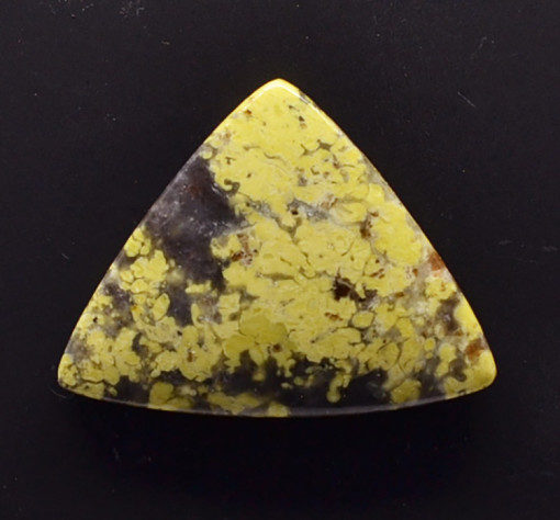 A yellow and black stone triangle on a black surface.