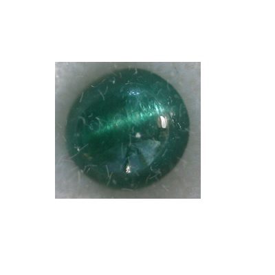 A green emerald stone on a white surface.