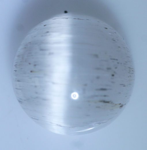 A sphere of white quartz on a white surface.