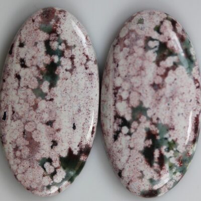 A pair of pink and white marble cabochons.