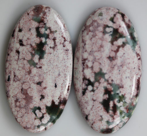 A pair of pink and white marble cabochons.