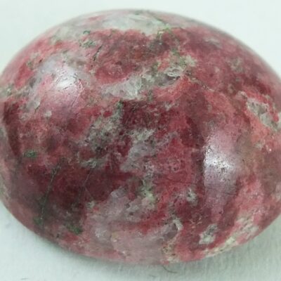 A pink stone ball on a white surface.