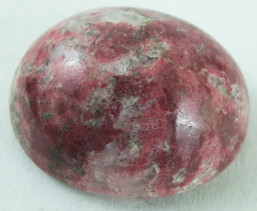 A pink stone ball on a white surface.