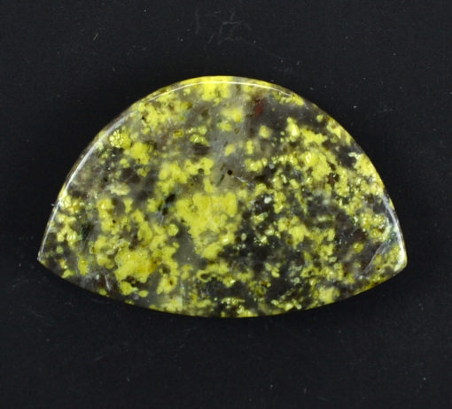 A yellow jasper pendant on a black surface.