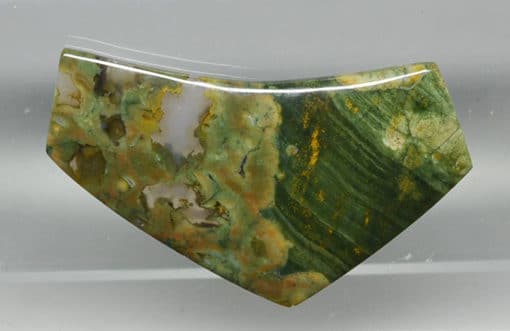 A green and yellow jade pendant on display.