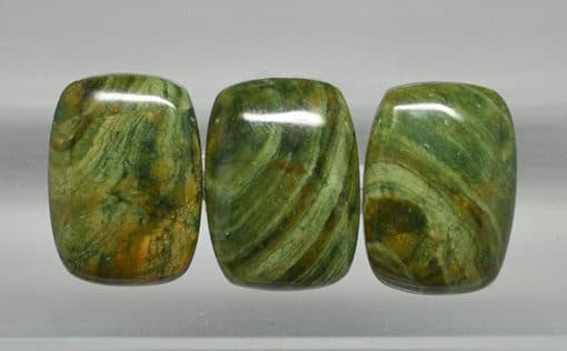 Three green marble cabochons on a white background.