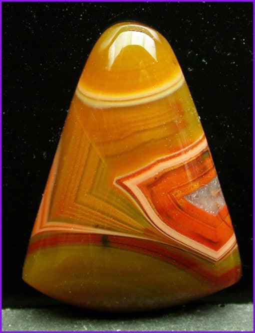 An orange and yellow agate stone on a black background.