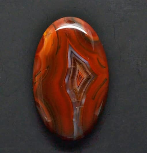 A piece of red agate on a black surface.