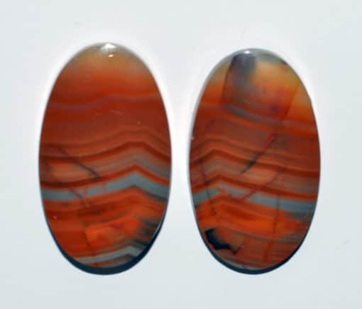 Two oval agate cabochons on a white surface.