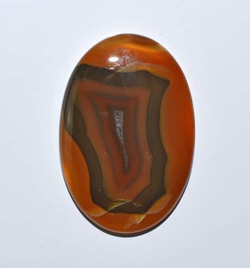 An oval agate stone on a white surface.