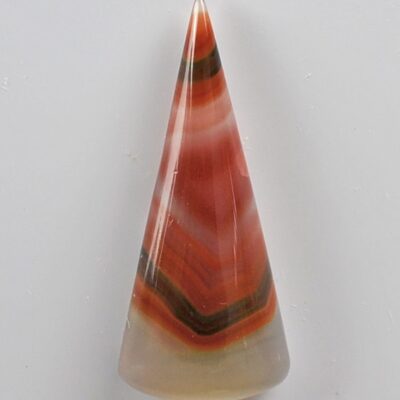 A cone shaped piece of agate on a white surface.