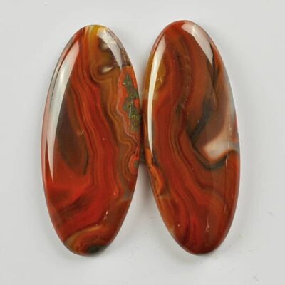 A pair of red agate oval cabochons.