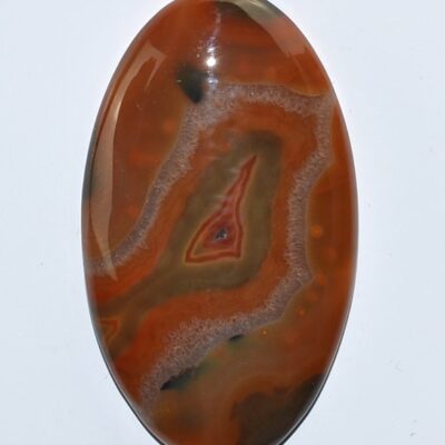 An orange and black agate oval cabochon.