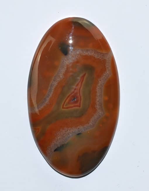An orange and black agate oval cabochon.