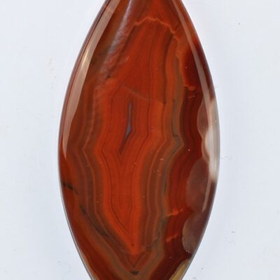 A piece of red agate on a white surface.