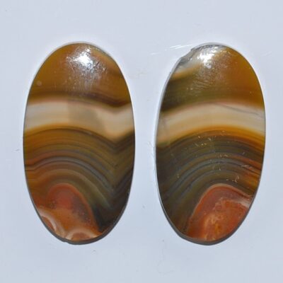 Two oval agate cabochons on a white surface.