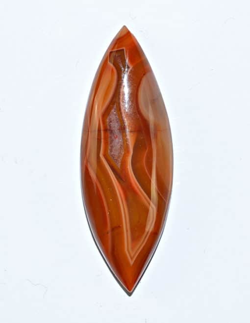 A brown and orange agate pendant on a white surface.