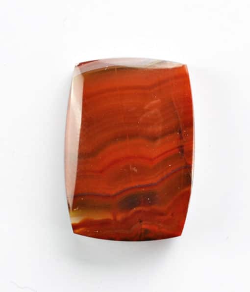 A piece of red agate on a white surface.