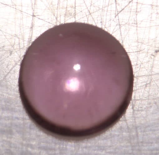 A purple stone on top of a white surface.