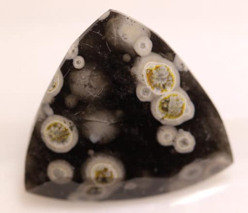 A black and white triangular shaped stone with white dots.