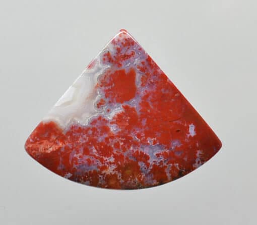 A red and white agate pendant on a white background.