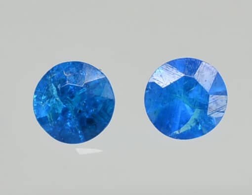 Two blue sapphire stones on a white background.