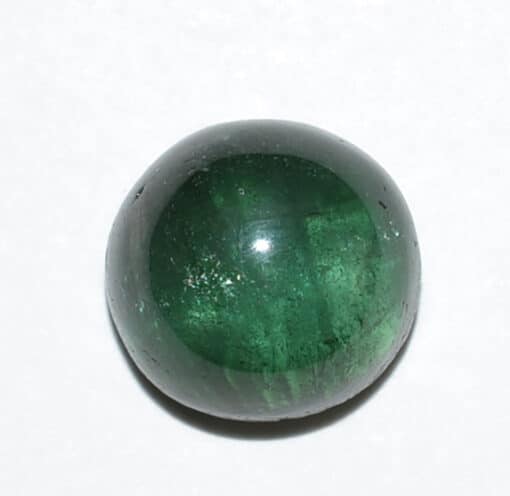An emerald shaped stone on a white surface.