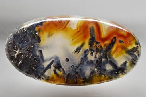 A piece of agate with orange and black swirls.