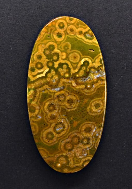 An oval shaped piece of yellow and green agate.