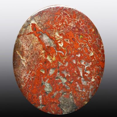 A red and black stone is shown on a black background.