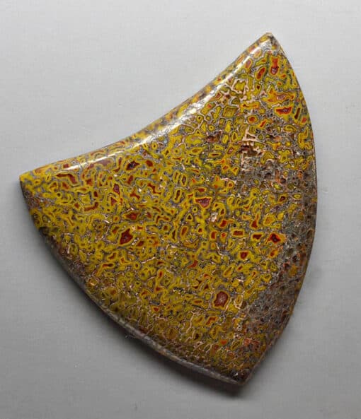 A yellow and brown piece of pottery on a white surface.