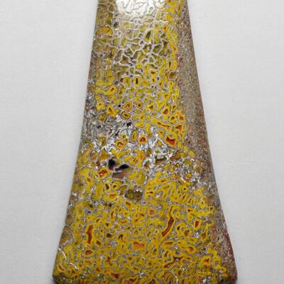 A yellow and black glass pendant on a white surface.