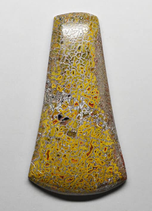 A yellow and black glass pendant on a white surface.