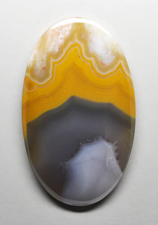 A yellow and white agate on a white surface.