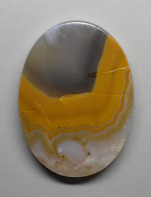 A yellow and brown agate on a white surface.