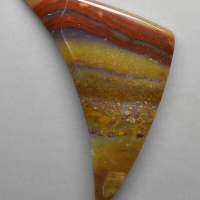 A piece of agate with a red, orange and yellow color.