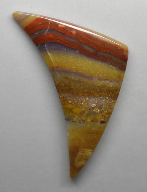 A piece of agate with a red, orange and yellow color.