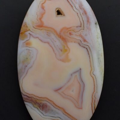 An oval agate pendant on a black surface.