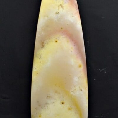 A piece of yellow jade on a black surface.