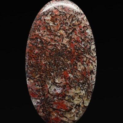 A red and brown stone on a black background.