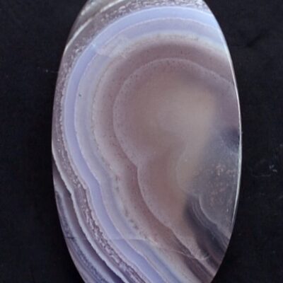 An oval agate stone with purple and blue swirls.