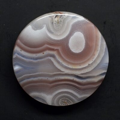 A round piece of agate with white and brown swirls.