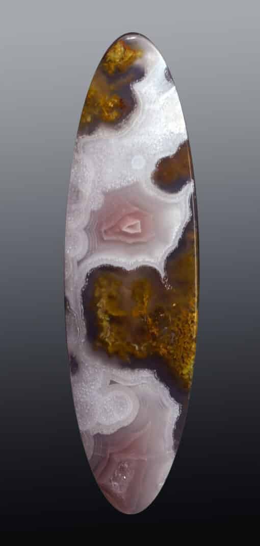 A round piece of agate with white and brown swirls.