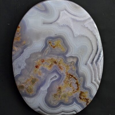 A round piece of agate on a black surface.