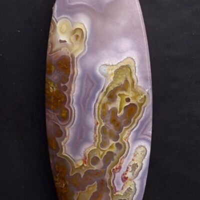 An oval piece of agate on a black background.