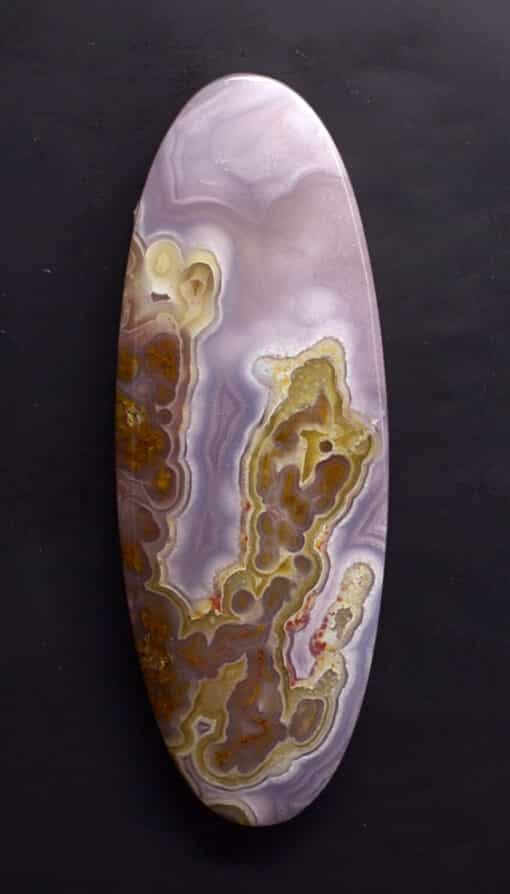 An oval piece of agate on a black background.