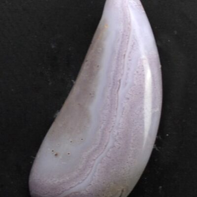 A piece of purple agate on a black surface.