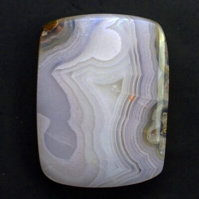 A square piece of agate on a black surface.